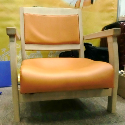 オレンジ色した座面の椅子が展示会場に置いてあります。