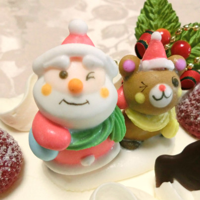 ムッシュマキノのクリスマスケーキの上では、サンタクロースと小熊が並んで見上げながらウィンクしています。