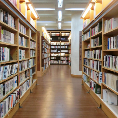 箕面中央図書館は、木製の床、木製の棚が左右と奥にたっていて多くの書物が収納されています。