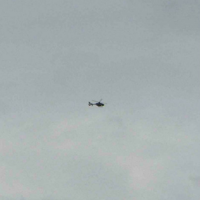 曇り空を背景に左から右に向かってヘリコプターが１機、飛んでいます。