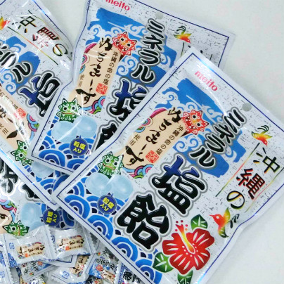 白い机のうえに「沖縄のミネラル塩飴」の袋がたくさんおいてあります。