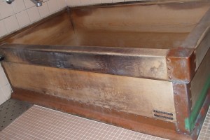 補修前の木製浴槽、右側は銅板が剥がれてきたので、ビニルテープで仮りどめしています。