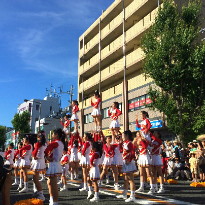 道では紅白の衣装を着た女子生徒達が肩に乗るなどの演技をしています。