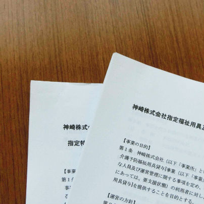 木目の机の上には白い紙を数枚束ねた原稿が二冊載っています。