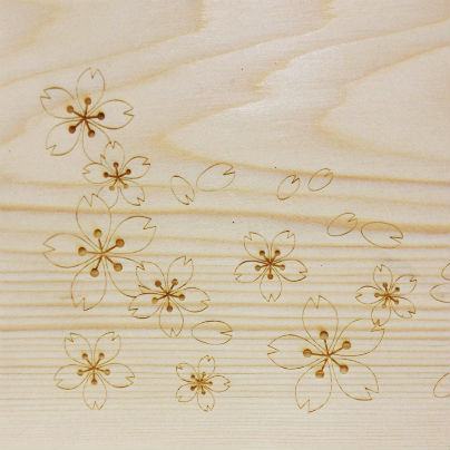 白い高野槙の板に花びらの柄が１０個ほど彫ってあります