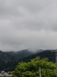 緑の木々が鮮やかな山の山頂付近にうっすらと雲がかかっております。