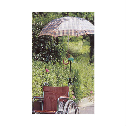 車椅子の背もたれポストに傘立てをとりつけ、傘を差しています。